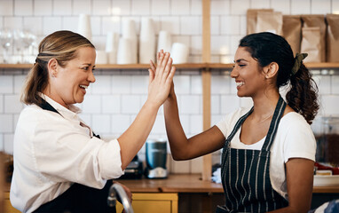 Business women, winning and cafe with high five for teamwork, success or collaboration in small bakery. Female people, employees or young waitress with smile for startup together at coffee shop