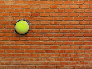 Tennis ball breaks through the wall, sports and strength concept.