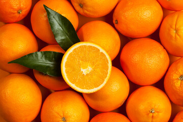 fresh oranges background, halved fruit with leaves on top