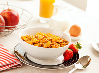 healthy breakfast with corn flakes, strawberries, apples, orange juice, egg and milk
