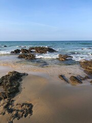 The beach, where the waves dance with the rocks in an eternal embrace, carving stories into the shore with each crash