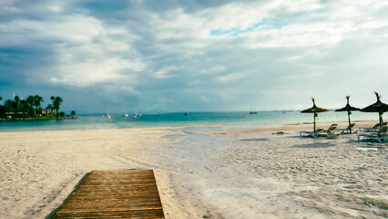 Mallorca, Spain. Serene Tropical Beach With Empty Chaise Lounges Under Cloudy Sky. Slight out of focus, copy space