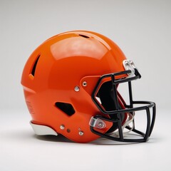 Fototapeta premium Isolated bright orange American football helmet with black faceguard against white backdrop highlights safety and sporty design