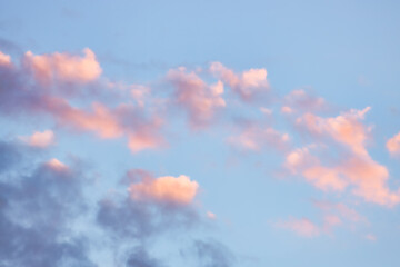 A beautiful sky tinted by the sun leaving vibrant shades of gold, pink, blue and multicolored. Clouds in the twilight evening and morning sky. Cloudy sky background in the evening, and during the day.