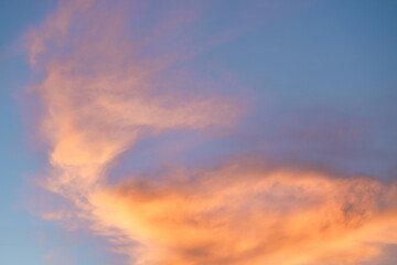 A beautiful sky tinted by the sun leaving vibrant shades of gold, pink, blue and multicolored. Clouds in the twilight evening and morning sky. Cloudy sky background in the evening, and during the day.