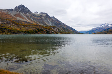 Scenic landscape with mountain panorama and Maloja Lake at Swiss mountain village of Maloja on a cloudy autumn day. Photo taken October 14th, 2024, Maloja, Switzerland.