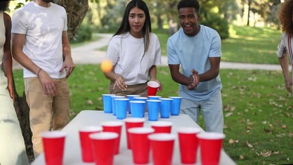 Friends playing beer pong celebrating victory