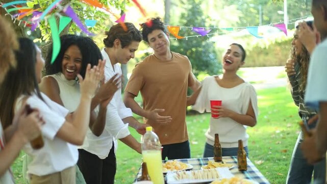 Group of friends congratulating man at birthday party