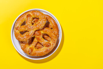 Pretzels scattered across a bright yellow background