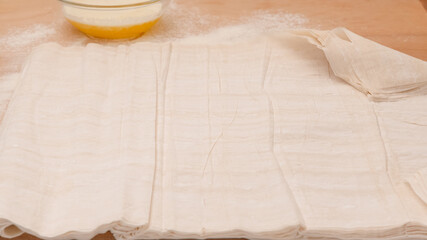 Phyllo dough and melted butter close-up on a wooden background
