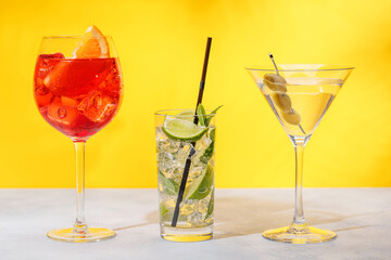 A variety of cocktails arranged on a table against a light yellow background