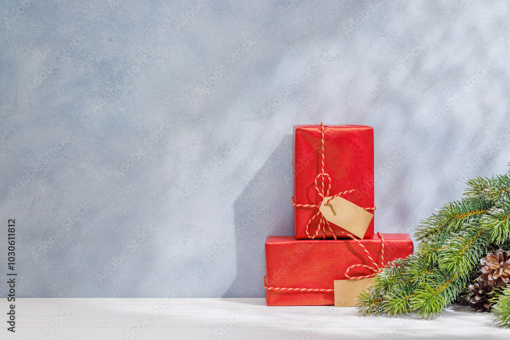 Aufkleber christmas template featuring gift boxes and snowy fir tree branches on a table with shadows and sun 