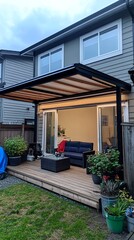 A modern, covered patio with a wooden deck, lounge furniture, and potted plants.