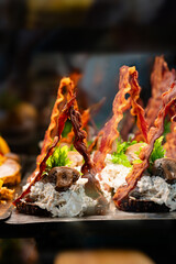 Danish open sandwich with meat salad and bacon on display in cafe.