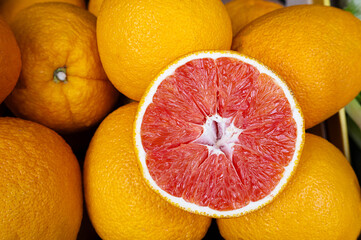 Orange grapefruit with red pulp at market, citrus background.