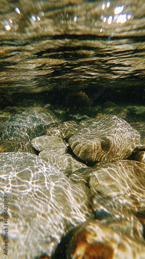 Poster close-up view of the bottom of a shallow stream with sunlight refracting through the water.