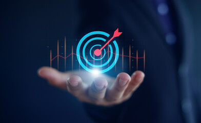 Target board inside magnifying glass for focus business objective on gray background and copy space. Search, goal, strategy, success.