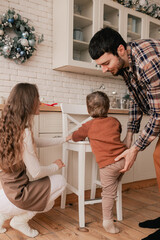 Fototapeta premium Happy moments in the family and time spent together with relatives on the eve of Christmas. Concept of gifts for New Year, Mother's Day and Father's Day. Modern kitchen interior. Part of a series