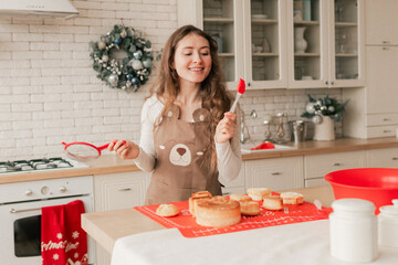 Closeup of young woman prepares a festive cupcake. Happy moments with relatives on the eve of Christmas. Modern kitchen interior. Part of 