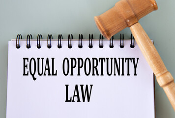 EQUAL OPPORTUNITY LAW - words in a notebook on a gray background with a judge's gavel