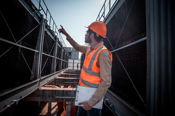 engineer under checking the industry cooling tower air conditioner is water cooling tower air chiller HVAC of large industrial building to control air system.	