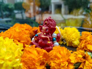 Lord Ganesha decorated with flowers beautiful red color ganpati bappa detailed sculpture, cute...