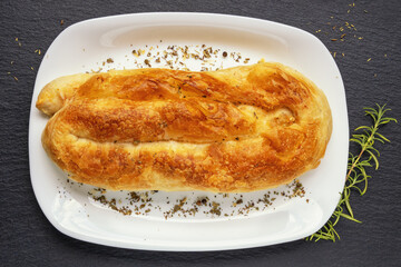 Balkan cuisine. Burek with cheese on white plate. Burek is filled pastry, popular national dish in Balkans