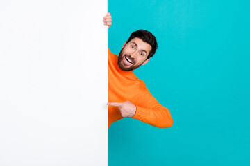 Photo of cheerful crazy cheerful man wearing stylish clothes presenting blank space isolated on...