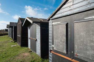 Row of timber built beach huts located near an English beach. Used as storage and changing rooms for private owners.