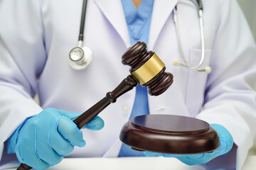 Doctor holding judge gavel, forensic medicine, medical law and crime justice concept.
