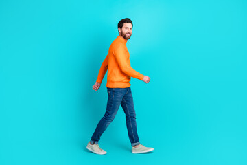 Photo of attractive positive nice man wear stylish clothes walk mall center isolated on aquamarine color background
