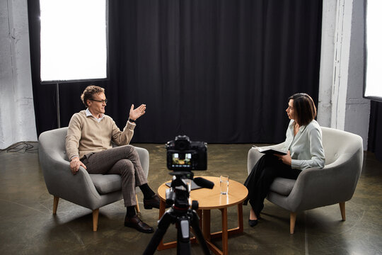 A professional journalist engages in an enlightening discussion with a male specialist in a sleek studio.