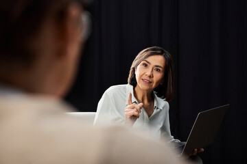 A middle-aged female journalist conducts an insightful interview with a specialist in a...