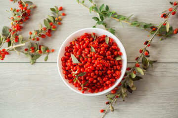 fresh ripe red goji berries in a bowl on a wooden table