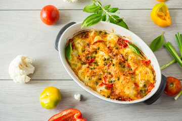 cauliflower baked with sweet pepper and vegetables under cheese