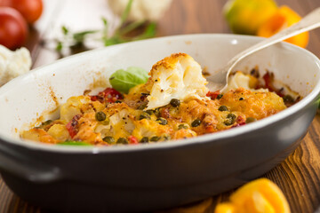 cauliflower baked with sweet pepper and vegetables under cheese