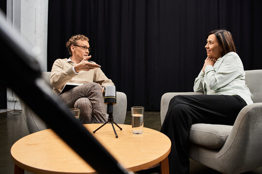 A journalist engages in a thoughtful interview with a specialist in a studio, capturing valuable insights.