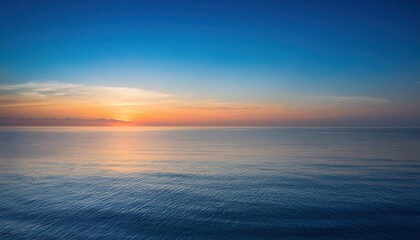 Obraz premium Majestic Ocean Sunset with Golden Horizon. Tranquil Waters Reflecting Vibrant Warm Colors in a Clear Sky, Ideal for Concepts of Peace, Meditation, Serenity, or Nature's Beauty at Dusk