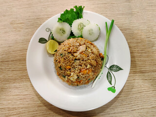 Authentic Thai chicken fried rice, served with fresh cucumber slices, lime, and green onions for a flavorful and refreshing meal.