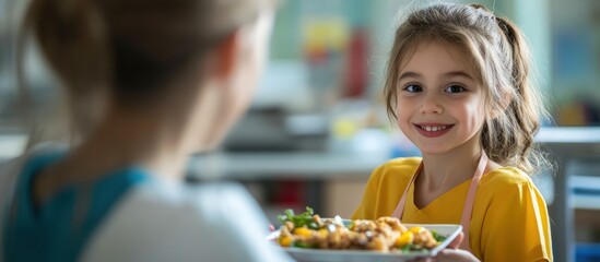 A young girl proudly presents a plate of food to an out-of-focus adult.