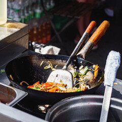 Chef Stir-Frying Sweet Chili Chicken with Vegetables in a Wok: Street Food Festival Scene