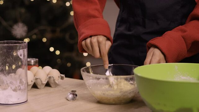 Woman preparing dough for gingerbread cookies in festive kitchen setting