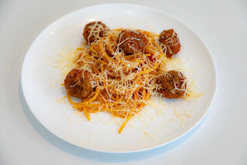 Traditional spaghetti with tomato sauce and meatballs and grated parmesan cheese