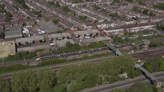 Aerial shot over Tottenham residential area with visible train tracks on a clear day in London, UK.