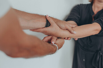 Two hands hold tightly to each other, rescuer saves, pulls out of trouble a person in need of help
