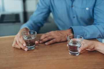 Business people discussing contract working together at meeting and holding a glass of water