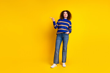 Fototapeta premium Full size photo of good mood girl with wavy hair wear knit pullover look directing at sale empty space isolated on yellow color background