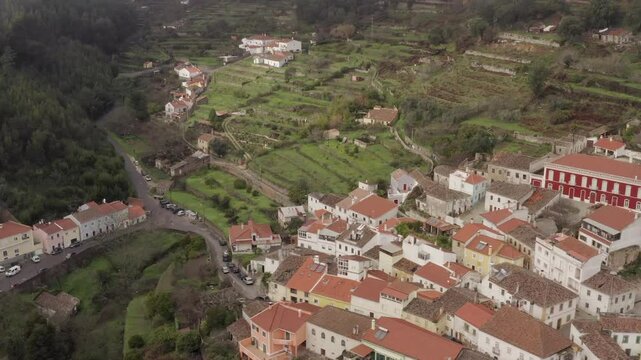 Aerial footage captures the picturesque village with red-roofed houses and lush green terraces in Monchique, Portugal.