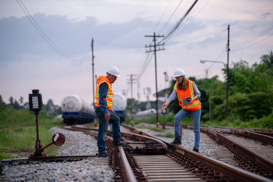 Engineer railway engaged in discussion or inspection maintenance work greenery and gas or oil power industrial or transportation setting in the rail train import export logistics industry concept.