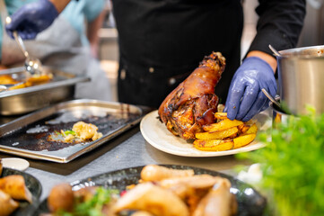 chef hand cooking Baked Pork knuckle